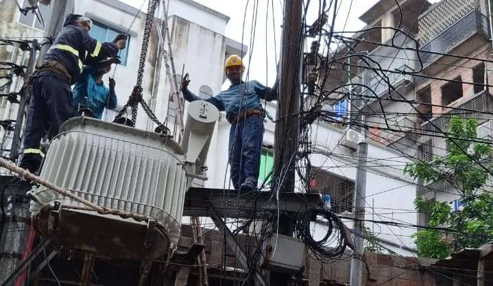 Electrical crew installing a distribution transformer