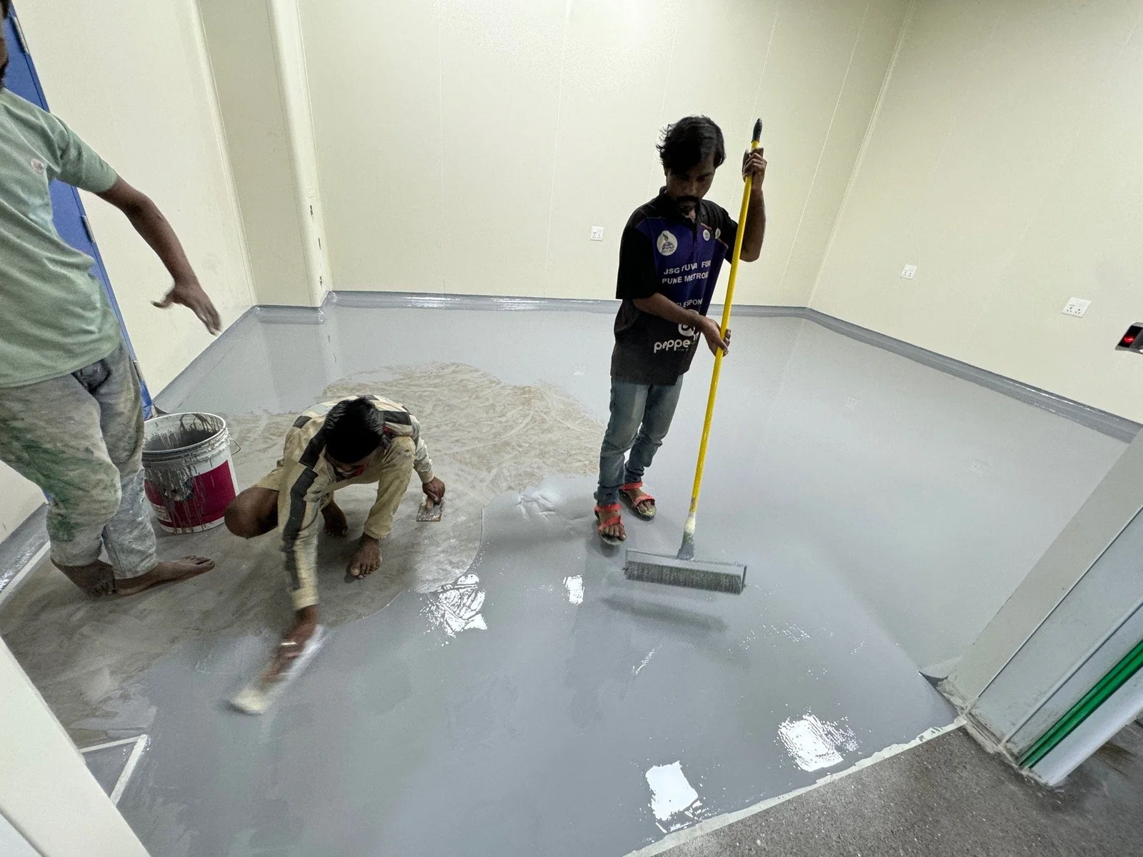 Workers applying a floor coating
